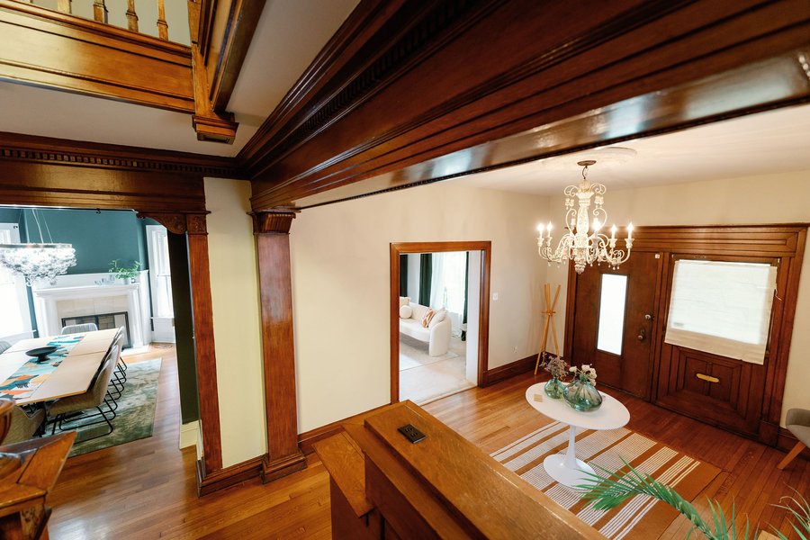 The entrance hall at Korédé House, with original dark woodwork and a chandelier