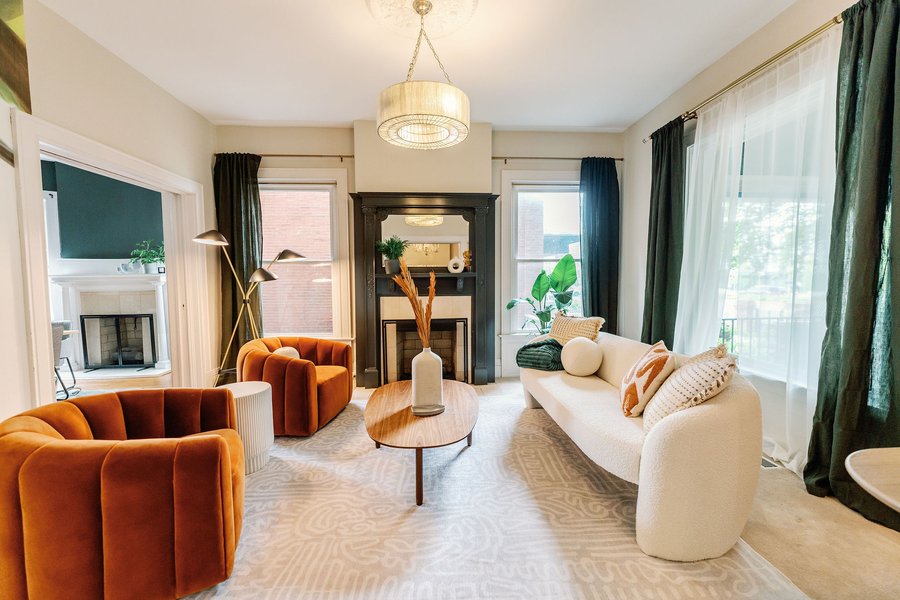 A parlour at Korédé House with rust velvet armchairs around a fireplace